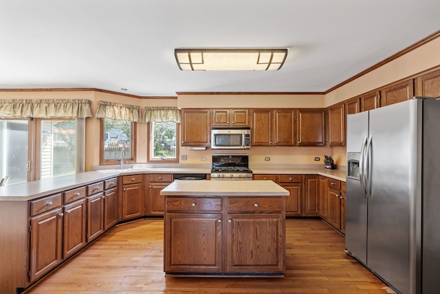 1304 Sheffield Ct, Carol Stream, IL 60188 - kitchen with stainless steel appliances, light countertops, a center island, ornamental molding, and light wood-style floors