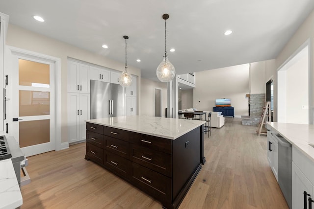 4216 Carpenter Rd, Naperville, IL 60564 - kitchen with appliances with stainless steel finishes, light wood finished floors, white cabinetry, light stone countertops, and decorative light fixtures