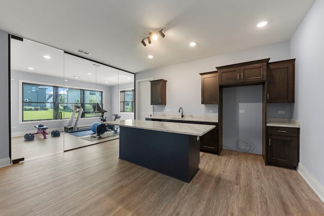 4216 Carpenter Rd, Naperville, IL 60564 - kitchen with dark brown cabinets, light wood-style flooring, a kitchen island, decorative light fixtures, and recessed lighting