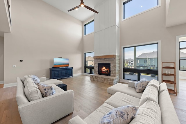 4216 Carpenter Rd, Naperville, IL 60564 - living area featuring high vaulted ceiling, ceiling fan, a stone fireplace, and light wood-style flooring