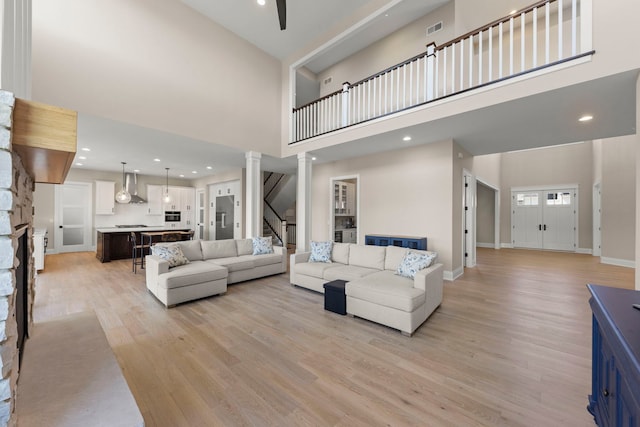 4216 Carpenter Rd, Naperville, IL 60564 - living area with a towering ceiling, light wood finished floors, decorative columns, a fireplace, and recessed lighting