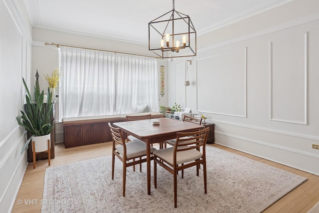 5245 N Winthrop Ave Unit 3S, Chicago, IL 60640 - dining room featuring a chandelier, crown molding, wood finished floors, and a decorative wall
