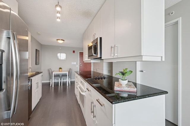 800 Elgin Rd Unit 1406, Evanston, IL 60201 - kitchen featuring stainless steel appliances, a textured ceiling, dark wood-style flooring, white cabinets, and dark stone counters