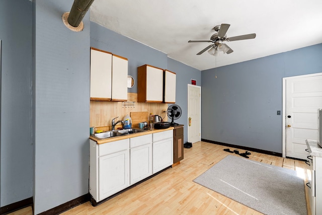 2421 W 21st Pl, Chicago, IL 60608 - kitchen with a ceiling fan, white cabinets, light wood finished floors, and light countertops