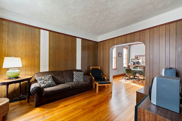 2421 W 21st Pl, Chicago, IL 60608 - living room featuring arched walkways, light wood-style floors, and wooden walls