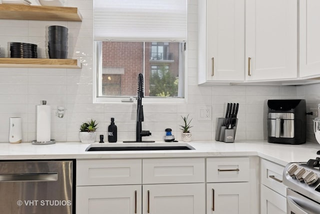 843 W College Pkwy, Chicago, IL 60608 - kitchen with stainless steel dishwasher, decorative backsplash, white cabinetry, open shelves, and range