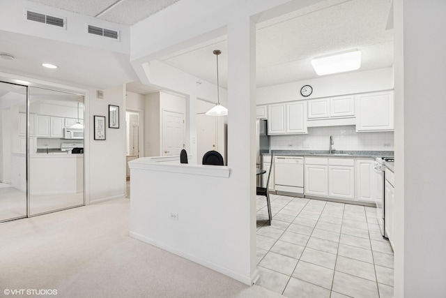 5055 W Madison St Unit 411, Skokie, IL 60077 - kitchen featuring white appliances, white cabinets, tasteful backsplash, decorative light fixtures, and light countertops