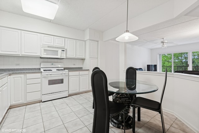 5055 W Madison St Unit 411, Skokie, IL 60077 - kitchen featuring white appliances, decorative backsplash, white cabinetry, light tile patterned flooring, and decorative light fixtures