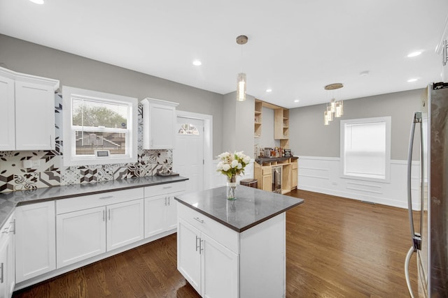 1028 N Lavergne Ave, Chicago, IL 60651 - kitchen with stainless steel refrigerator, dark countertops, dark wood-type flooring, wainscoting, and white cabinetry