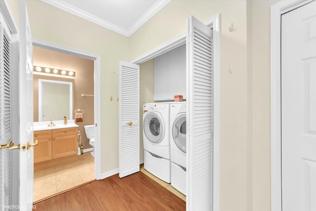 640 Mchenry Rd Unit 106, Wheeling, IL 60090 - washroom with crown molding, cabinet space, washer and dryer, and light wood-style flooring