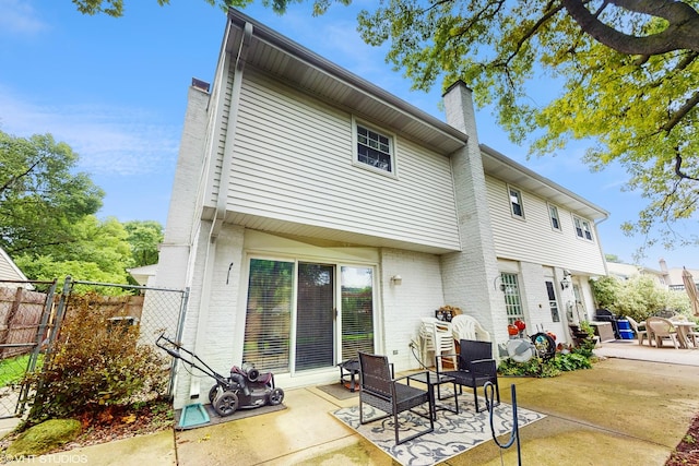 1502 S Fernandez Ave, Arlington Heights, IL 60005 - back of property with a patio, a chimney, and brick siding