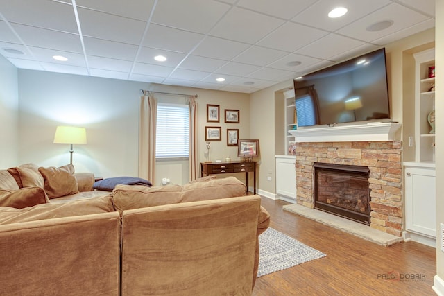870 Symphony St, Lake Forest, IL 60045 - living room featuring built in shelves, wood finished floors, a fireplace, and a paneled ceiling