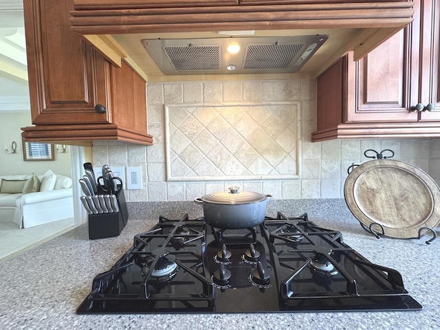 2305 Fox Run Dr, Kankakee, IL 60901 - kitchen with black gas stovetop, extractor fan, backsplash, and brown cabinets