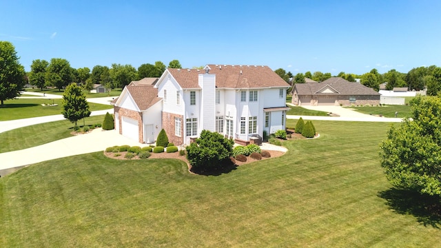 2305 Fox Run Dr, Kankakee, IL 60901 - traditional-style home with driveway, a chimney, a front yard, and a garage