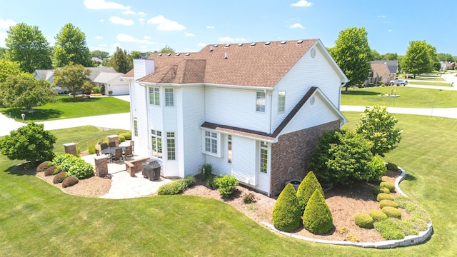 2305 Fox Run Dr, Kankakee, IL 60901 - rear view of property with a chimney, a patio, a lawn, and roof with shingles