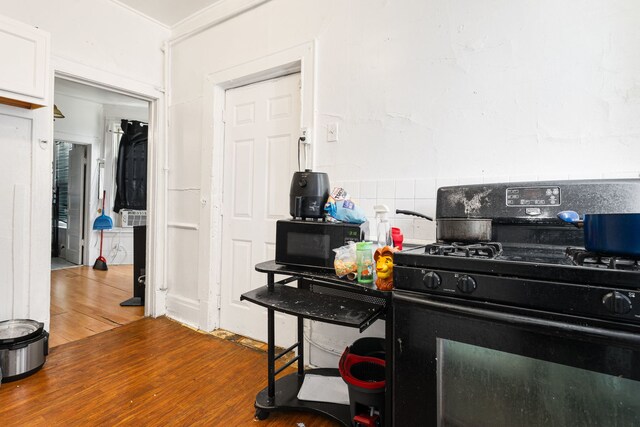 15 N Washtenaw Ave, Chicago, IL 60612 - kitchen featuring black appliances, wood finished floors, and white cabinetry