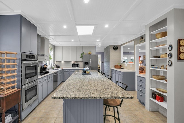 201 E Sherwin Dr, Urbana, IL 61802 - kitchen with stainless steel appliances, gray cabinetry, a breakfast bar, recessed lighting, and light tile patterned floors