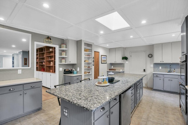 201 E Sherwin Dr, Urbana, IL 61802 - kitchen featuring gray cabinetry, a center island, a skylight, light tile patterned floors, and recessed lighting
