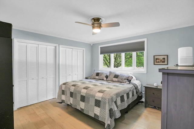 201 E Sherwin Dr, Urbana, IL 61802 - bedroom featuring multiple closets, light wood-style flooring, ornamental molding, and ceiling fan