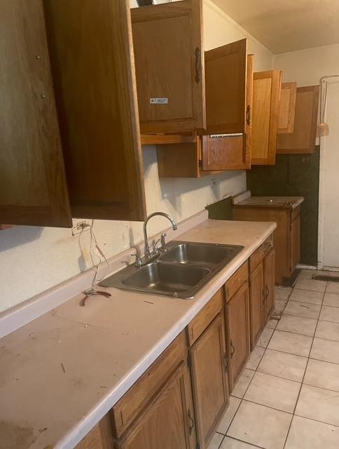 15239 Calitonia Dr, Markham, IL 60428 - kitchen featuring brown cabinetry, light tile patterned flooring, and light countertops