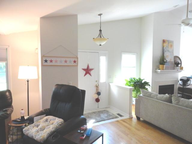 foyer with wood finished floors, a fireplace, and a ceiling fan