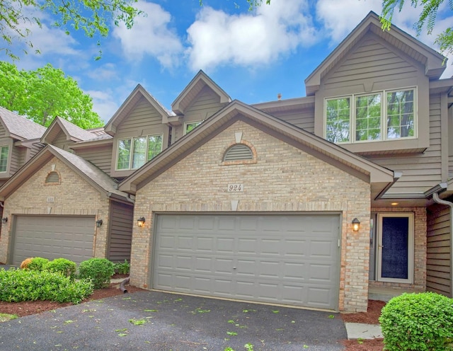 924 Millcreek Cir, Elgin, IL 60123 - view of property featuring asphalt driveway, brick siding, and an attached garage