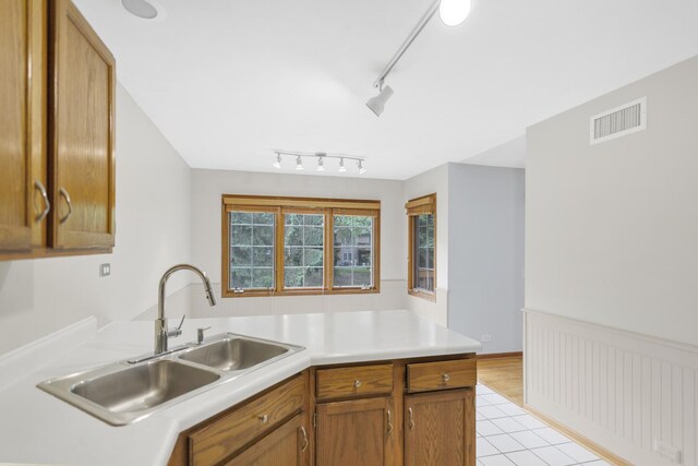 924 Millcreek Cir, Elgin, IL 60123 - kitchen featuring light countertops, light tile patterned flooring, a peninsula, track lighting, and brown cabinetry