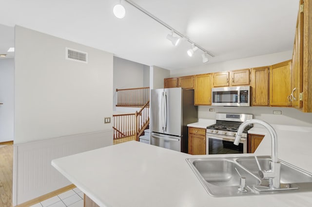 924 Millcreek Cir, Elgin, IL 60123 - kitchen featuring stainless steel appliances, a wainscoted wall, light countertops, track lighting, and a peninsula