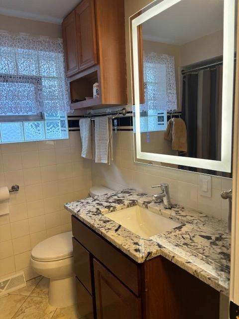 5131 S Latrobe Ave, Chicago, IL 60638 - bathroom with vanity, tile walls, tile patterned floors, and decorative backsplash