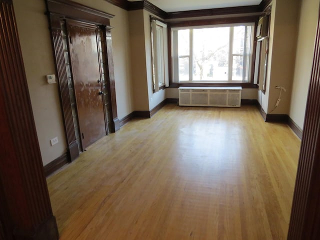 7120 S Eberhart Ave, Chicago, IL 60619 - unfurnished room with light wood-style floors, radiator, and crown molding