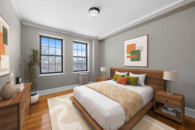 3017 E 78th St Unit 4B, Chicago, IL 60649 - bedroom featuring radiator, wood finished floors, and crown molding