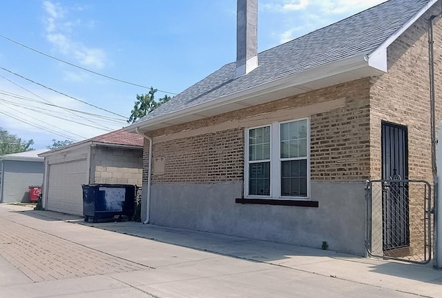 6084 S 75th Ave, Summit, IL 60501 - view of property exterior featuring a chimney, a shingled roof, an outbuilding, a detached garage, and brick siding