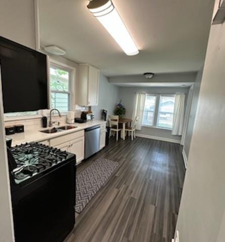 3708 N Oketo Ave, Chicago, IL 60634 - kitchen featuring black range with gas cooktop, stainless steel dishwasher, white cabinetry, light countertops, and dark wood-style floors