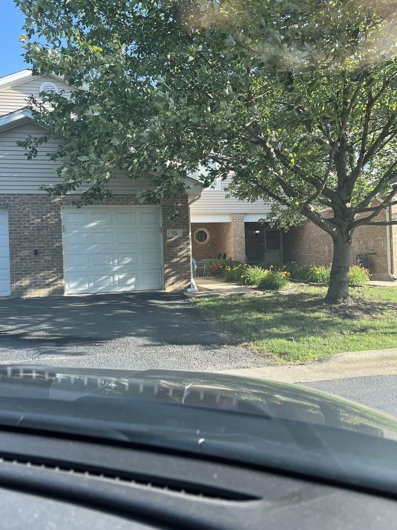 obstructed view of property with brick siding and driveway