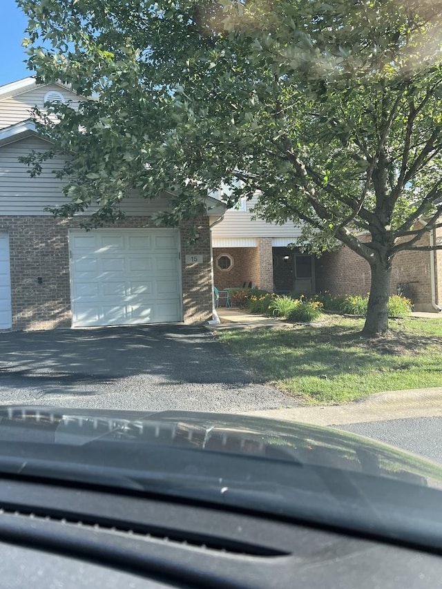obstructed view of property with brick siding and driveway