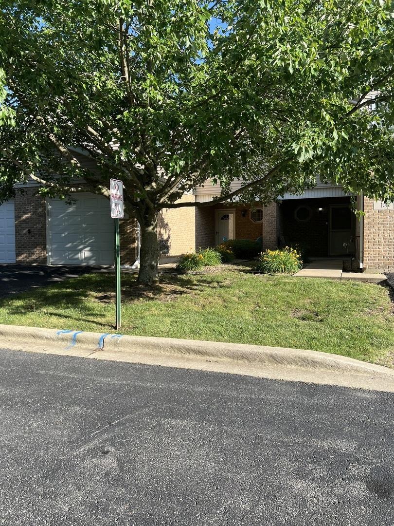 obstructed view of property with brick siding and a front lawn