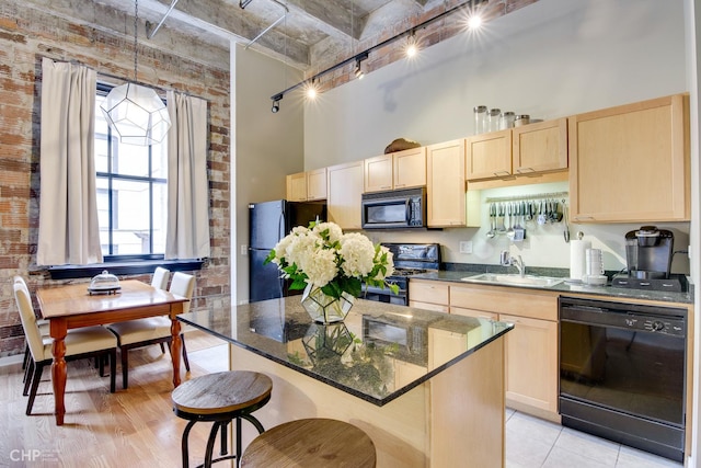 20 N State St Unit 909, Chicago, IL 60602 - kitchen with black appliances, light brown cabinetry, a towering ceiling, a kitchen island, and a kitchen bar
