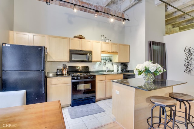 20 N State St Unit 909, Chicago, IL 60602 - kitchen featuring black appliances, a high ceiling, light brown cabinets, track lighting, and light tile patterned flooring