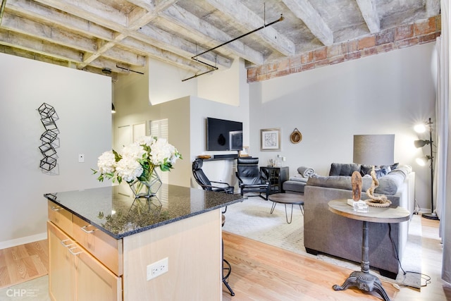 20 N State St Unit 909, Chicago, IL 60602 - kitchen featuring a towering ceiling, open floor plan, light wood finished floors, a kitchen breakfast bar, and light brown cabinets