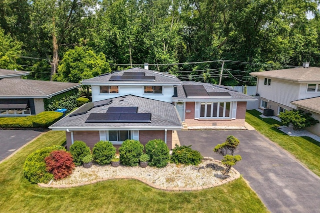 9070 Shady Ln, Hickory Hills, IL 60457 - view of front of home with roof mounted solar panels, brick siding, a shingled roof, a front lawn, and driveway