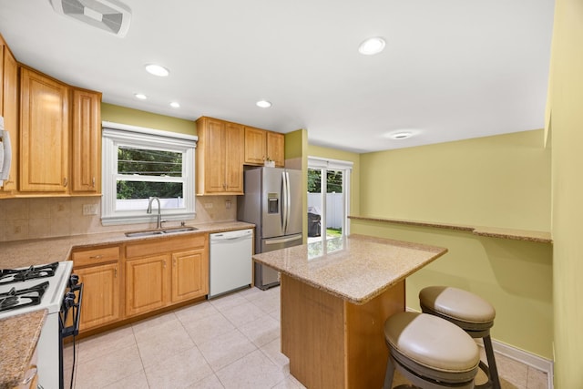 9070 Shady Ln, Hickory Hills, IL 60457 - kitchen with white appliances, a kitchen breakfast bar, decorative backsplash, light tile patterned floors, and recessed lighting