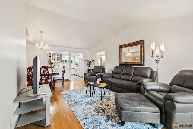 6561 W School Ave Unit 305C, Chicago, IL 60634 - living room featuring a chandelier, vaulted ceiling, and light wood-style flooring