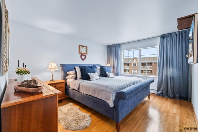6561 W School Ave Unit 305C, Chicago, IL 60634 - bedroom featuring light wood finished floors and a baseboard radiator