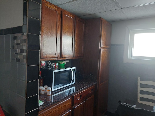 4421 W 87th St, Hometown, IL 60456 - kitchen featuring stainless steel microwave, tile walls, dark stone countertops, radiator heating unit, and wainscoting