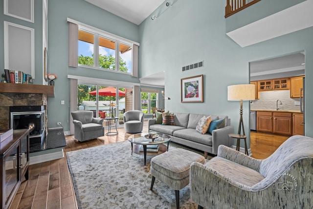 482 River Front Cir, Naperville, IL 60540 - living area featuring a high ceiling, a stone fireplace, and dark wood-style floors