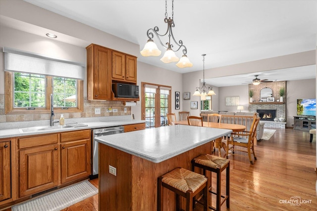 10660 Great Egret Dr, Orland Park, IL 60467 - kitchen featuring dishwasher, a kitchen breakfast bar, ceiling fan, a brick fireplace, and light wood finished floors