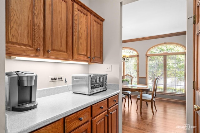 10660 Great Egret Dr, Orland Park, IL 60467 - kitchen with brown cabinets, light countertops, light wood finished floors, and crown molding