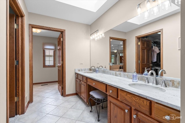 10660 Great Egret Dr, Orland Park, IL 60467 - bathroom featuring double vanity, a spacious closet, a skylight, and tile patterned floors