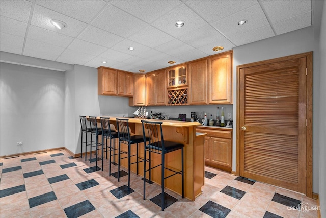 10660 Great Egret Dr, Orland Park, IL 60467 - kitchen featuring a breakfast bar area, a drop ceiling, glass insert cabinets, light countertops, and recessed lighting