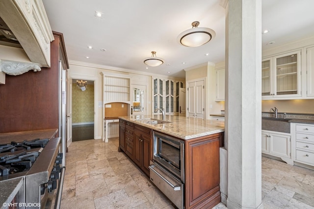 1550 N State Pkwy Unit 801, Chicago, IL 60610 - kitchen with stainless steel microwave, crown molding, light stone counters, stone tile flooring, and glass insert cabinets